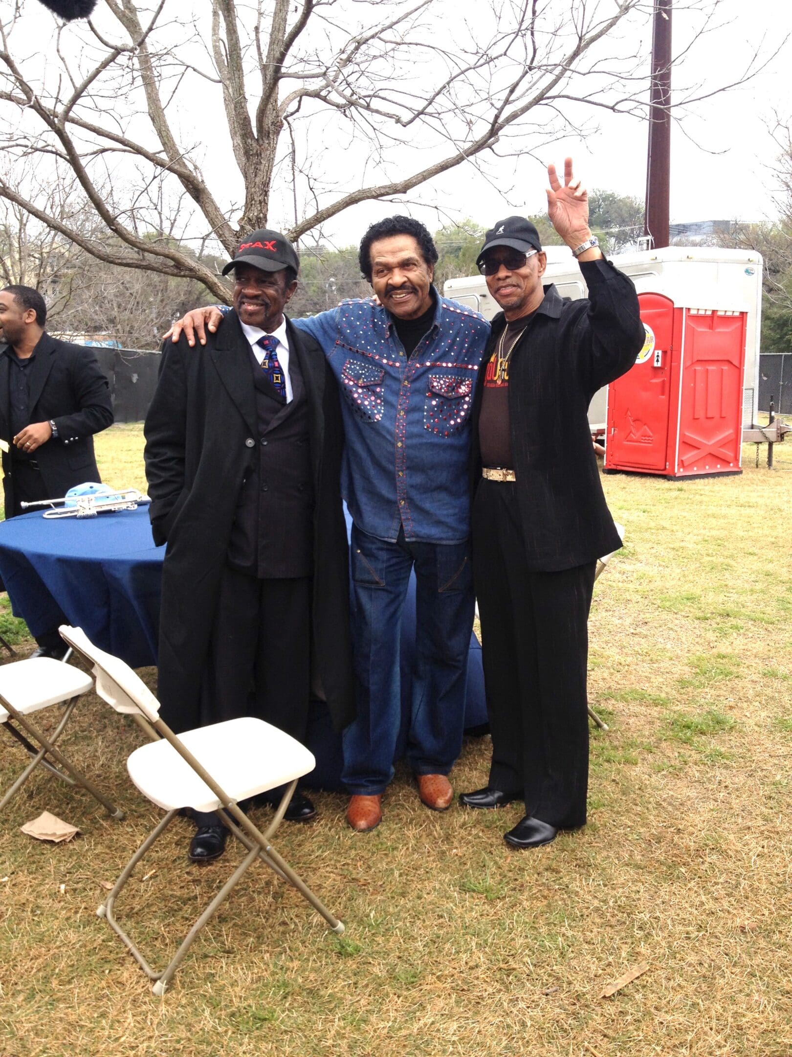 Three men standing next to each other in a field.