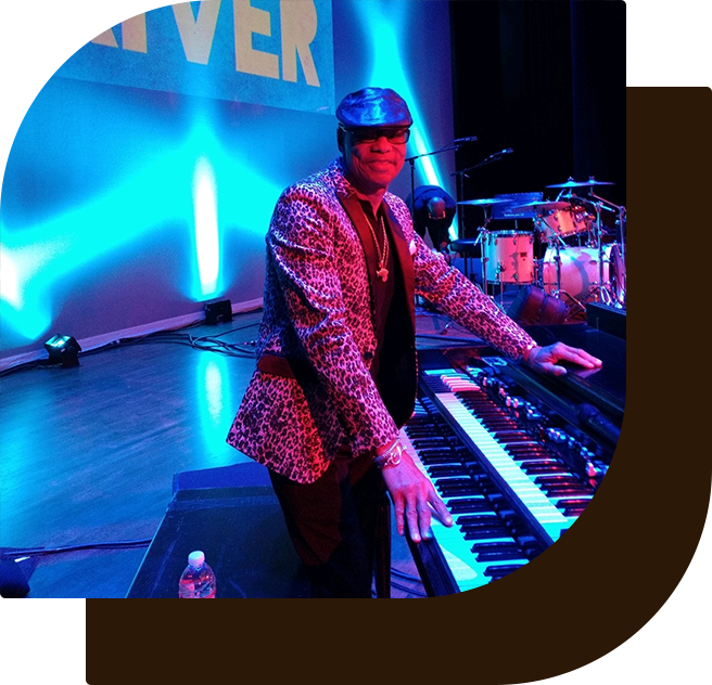 A man in a suit and helmet standing next to a piano.